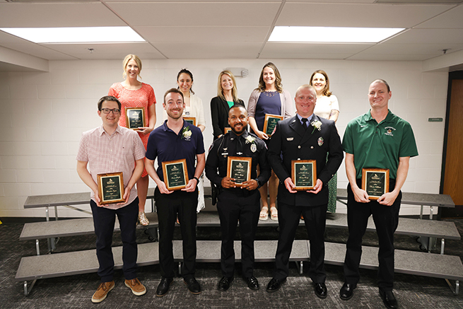 10 individuals stand with plaques after winner Pride of Pattonville award